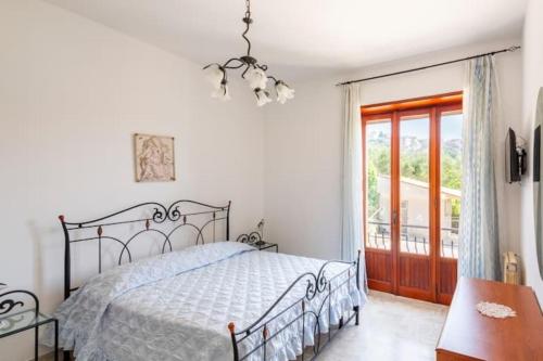 a bedroom with a bed and a window and a chandelier at Villa Lucia Guesthouse Minturno in Minturno
