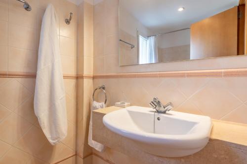 a bathroom with a white sink and a mirror at Talaia Bajos A in Port de Pollensa