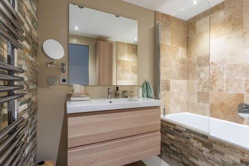 a bathroom with a tub and a sink and a shower at Maison Sainte-Maxime avec jardin in Le Plan