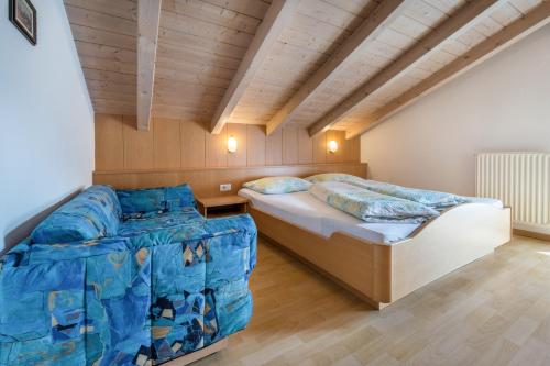 a bedroom with two beds and a wooden ceiling at App Sonne Nr 20 in Lutago