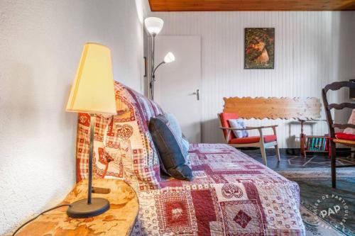 a bedroom with a bed with a lamp on a table at Apt Morzine 1000 in Morzine