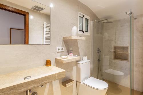 a bathroom with a toilet and a shower and a sink at Casa Magui in Capdepera