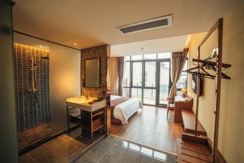 1 dormitorio con cama y baño con espejo. en James Joyce Hotel Zhuhai Hengqin Chimelong, en Zhuhai