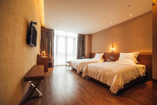 a hotel room with two beds and a television at James Joyce Hotel Zhuhai Hengqin Chimelong in Zhuhai