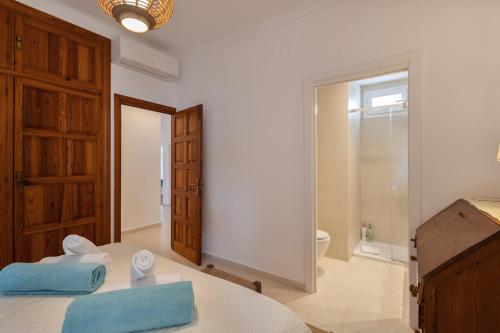 a bedroom with a bed with blue towels on it at Can Joan Durban in Sant Joan de Labritja