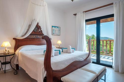 a bedroom with a bed with a chair and a balcony at Can Joan Durban in Sant Joan de Labritja