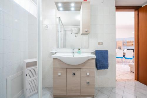 a white bathroom with a sink and a mirror at Casa Vacanze 4 Venti in Muravera