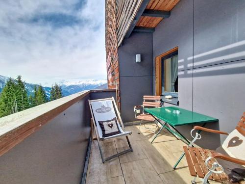 a balcony with a green table and chairs on it at Apartment Naviser Hütte-3 by Interhome in Navis
