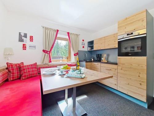 a kitchen with a wooden table and a red couch at Apartment Naviser Hütte-3 by Interhome in Navis