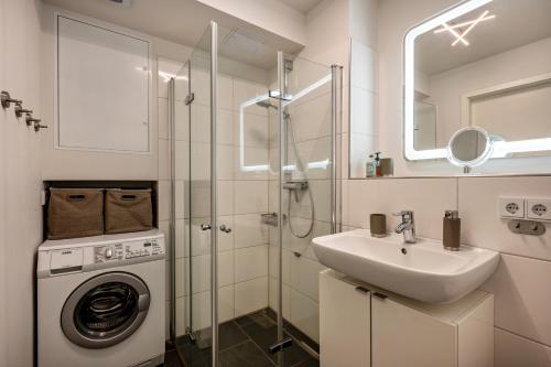 a bathroom with a washing machine and a sink at Ferienwohnung Moin am Meer in Scharbeutz