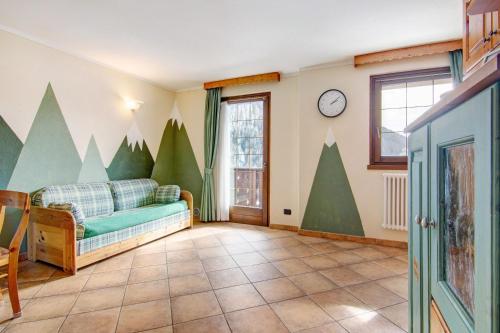 a living room with a couch and a clock on the wall at Residence Larice Bianco App n2 in Campodolcino