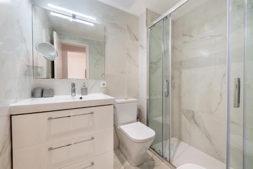 a bathroom with a toilet and a glass shower at Mercuri in Port d'Alcudia