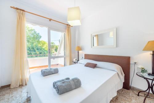 a bedroom with a white bed and a large window at Mercuri in Port d'Alcudia