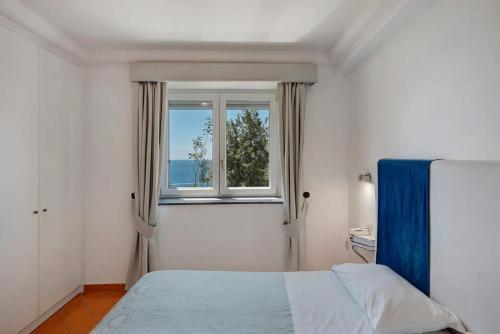 a bedroom with a bed and a window at Luxury Villa Seaview con jacuzzi in Conca dei Marini