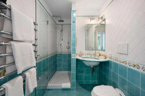 a bathroom with a sink and a toilet and a mirror at Luxury Villa Seaview con jacuzzi in Conca dei Marini