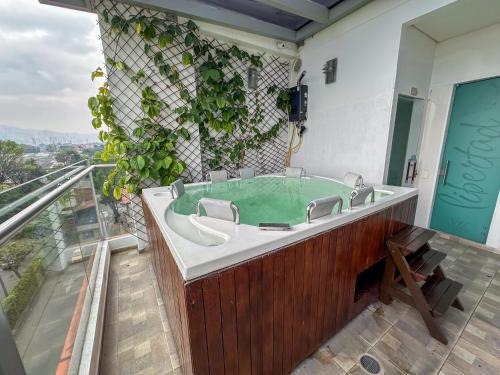 a bathroom with a bath tub with green water at Hotel Sixtina Plaza Medellin in Medellín
