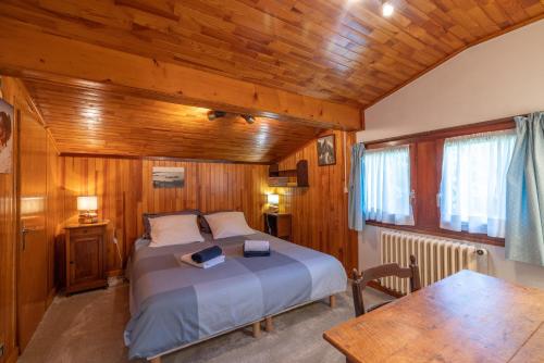 a bedroom with a bed in a wooden room at Chalet Le Margouillat in Les Houches