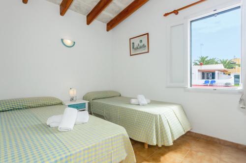 two twin beds in a room with a window at Son Xoriguer 14 in Son Xoriguer