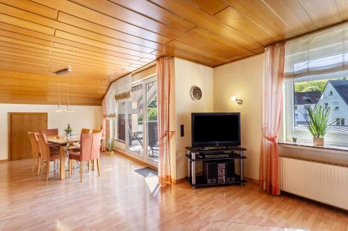 a living room with a table and a television at Ferienwohnung Urban in Bestwig