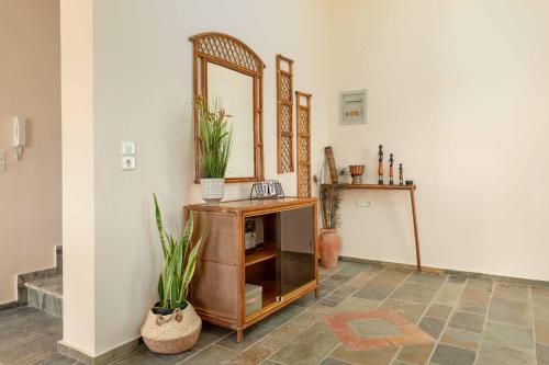 a room with a mirror and a cabinet with plants at Villa Melenia 2 in Agia Pelagia