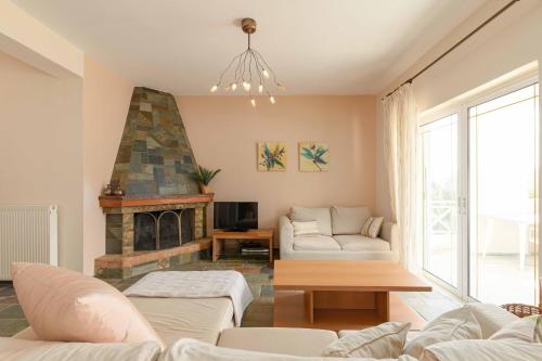 a living room with a couch and a fireplace at Villa Melenia 2 in Agia Pelagia
