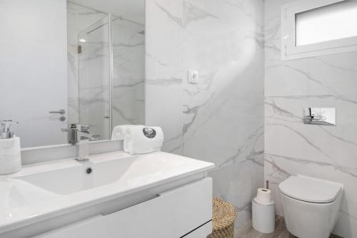 a white bathroom with a sink and a toilet at Apulia Apartment in Apúlia