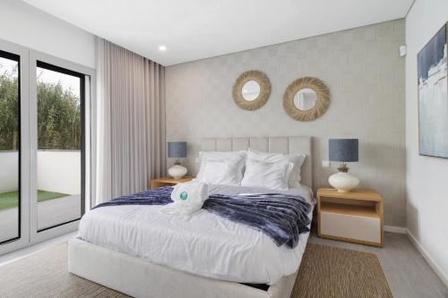 a bedroom with a large bed with two mirrors on the wall at Apulia Apartment in Apúlia