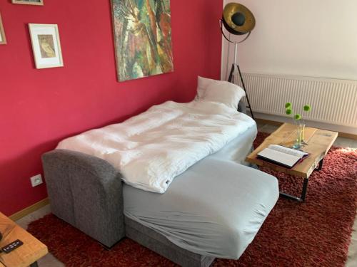 a bed in a room with a table and a chair at Draußen am See in Losheim