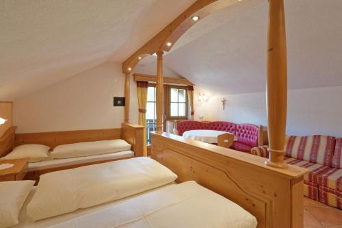 a room with two beds and a couch at Bruneggerhof Weissenbach in Rio Bianco