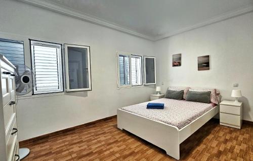 a white bedroom with a bed and some windows at Apartamento Galoponte - Laaldeabnb in San Nicolás