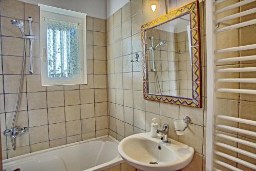 a bathroom with a sink and a tub and a mirror at Villa Ostria in Tsoukalades