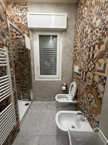 a bathroom with two toilets and a sink and a window at Valepiace 1 in Piacenza