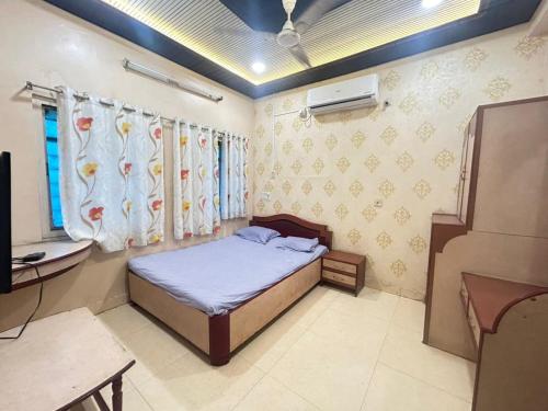 a bedroom with a bed and a desk and a television at Hotel Shiv-Shakti in Solapur