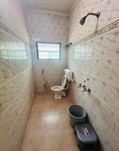 a bathroom with a toilet and a shower at Hotel Shiv-Shakti in Solapur