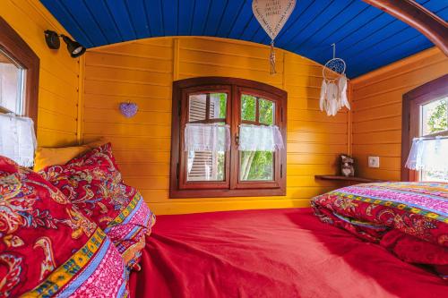 a bedroom with two beds and a blue ceiling at Roulotte la casetta Rita in Chambon
