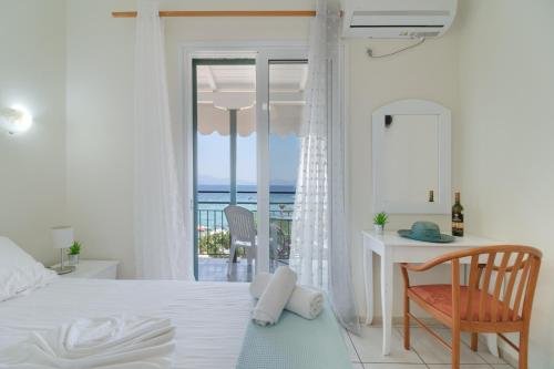 a bedroom with a bed and a desk with a view of the ocean at S7 apartment in Nikiana