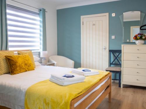 a bedroom with a bed with towels on it at Chalet Skeabost Chalet by Interhome in Tole