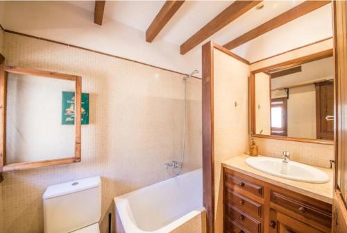 a bathroom with a tub and a sink and a mirror at Ca Na Magda in Port de Soller