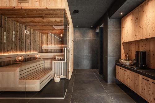 a sauna with wood paneling and a glass wall at Bruneggerhof Weissenbach in Rio Bianco