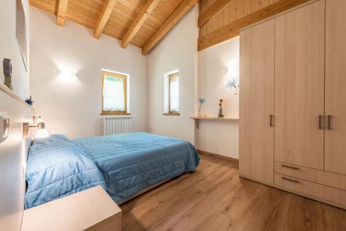 a bedroom with a blue bed and wooden ceilings at Nonno Bigi Genziana in Tremosine Sul Garda