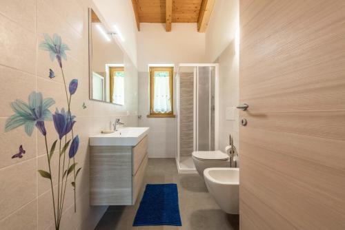 a bathroom with a white toilet and a sink at Nonno Bigi Genziana in Tremosine Sul Garda