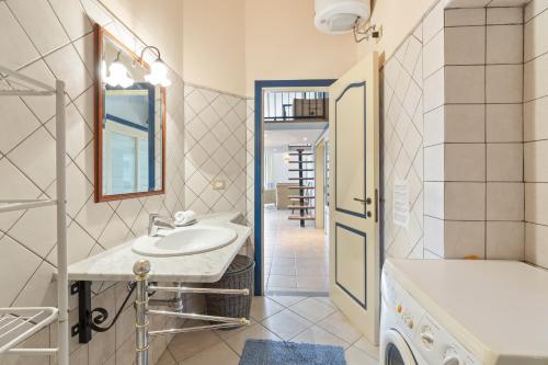a bathroom with a sink and a washing machine at Le Residenze In Piazza in Bosa