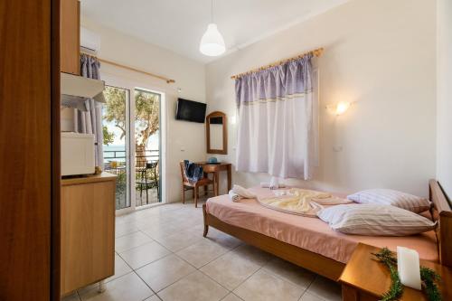 a bedroom with a bed and a table and a window at Nikiana Club - Studio 2 in Nikiana