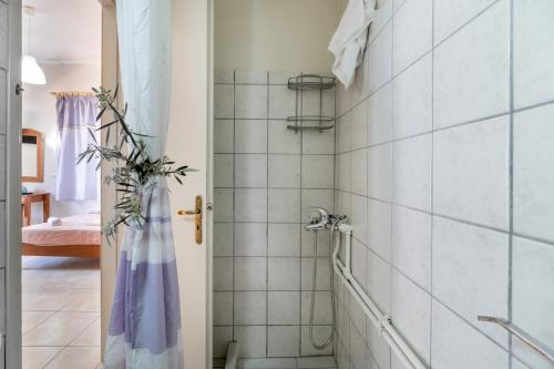 a bathroom with a shower with white tiles at Nikiana Club - Studio 2 in Nikiana