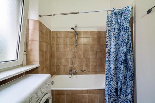 a bathroom with a tub and a shower curtain at Residence Hubertus Apartment 4 in Merano
