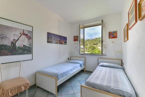a room with two beds and a window at Appartamento Trilo Fucini in Campo nell'Elba