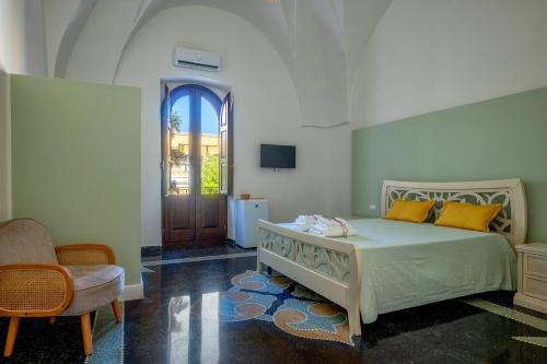 a bedroom with a bed and a chair and a door at Gma Home Primo Piano in Pulsano
