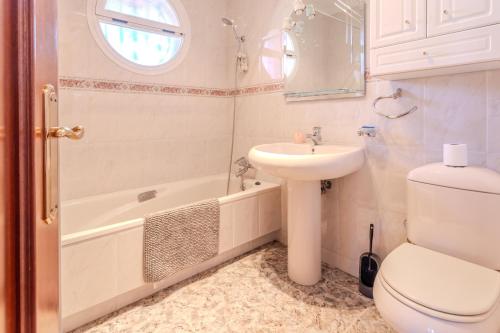 a bathroom with a sink and a toilet and a tub at Villa natura 20 km de las playas in Sils