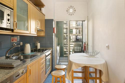 a kitchen with a sink and a table with stools at Oliveira Atlantic View in Funchal