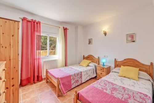 a bedroom with two beds and a window at Can Parets in Santanyi